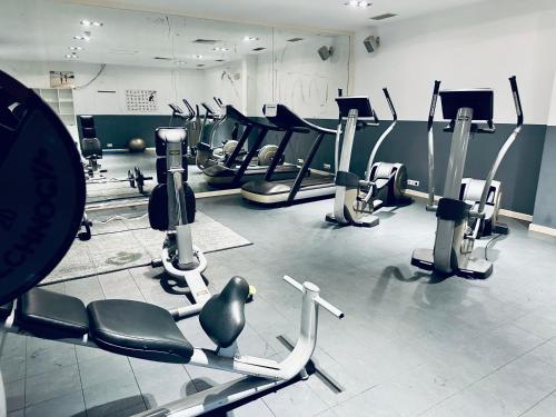 a gym with several rows of treadms and machines at Spacious Apartment @MeliaTortugaResort in Prainha