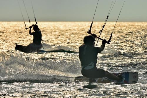 dos personas están haciendo windsurf en el océano en Nisi Glamping en Paralía
