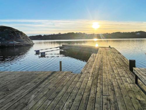 a dock on a body of water with the sun setting at 12 person holiday home in Nösund-By Traum in Nösund