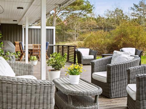 a patio with wicker chairs and tables on a deck at 12 person holiday home in Nösund-By Traum in Nösund