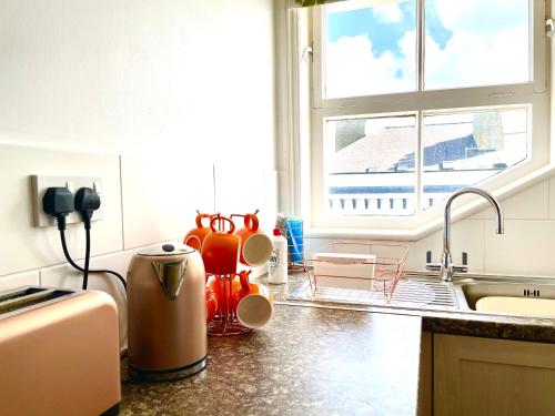 uma cozinha com comodidades para preparar café num balcão ao lado de uma janela em Fayvan Apartments em Whitby