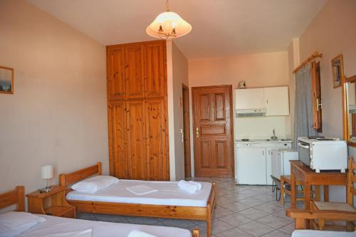 a room with two beds and a kitchen at Nikos Studios in Gialiskari