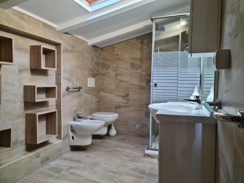 uma casa de banho com um WC, um lavatório e um espelho. em Villa Victoria em Lierna