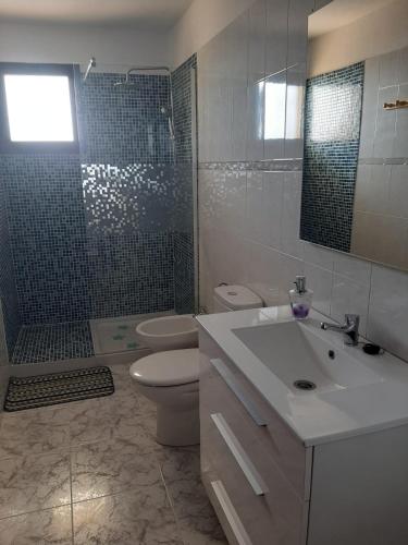 y baño con lavabo, aseo y ducha. en Casitas Conchi A, en Monte de Breña
