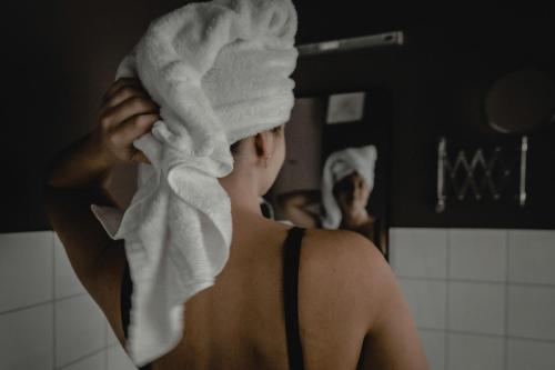 Una mujer tiene una toalla en la cabeza. en Kastanienhof Pfettrach en Altdorf