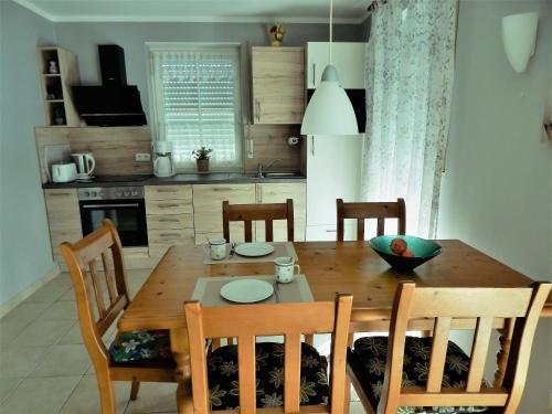 a kitchen with a wooden dining room table and chairs at Strandoase Typ STO-A STRANDOASE Whg. SO2 in Wustrow