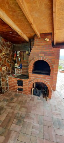 una chimenea de ladrillo en una habitación con techo en View Cozia, en Călimăneşti