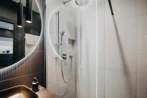 uma casa de banho com um lavatório e um chuveiro em Black&White Bukowska18 B Apartment with Balcony and Garage em Poznań