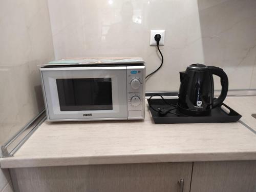 eine Mikrowelle auf einer Theke mit Kaffeemaschine in der Unterkunft Nikos house studios in Ofrynio