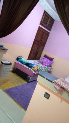 - une chambre avec un lit dans une pièce aux murs violets dans l'établissement DAKHLA, à Dakhla