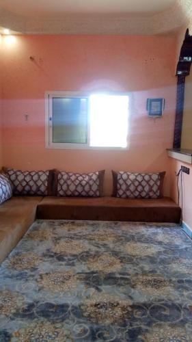 ein Sofa in einem Zimmer mit Fenster in der Unterkunft DAKHLA in Ad-Dakhla