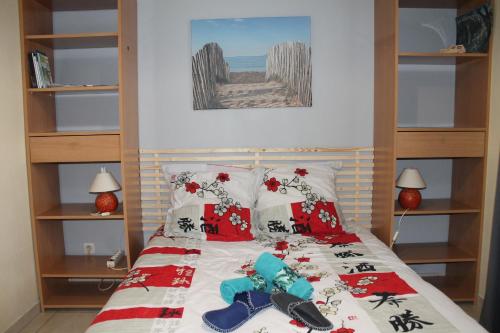 Schlafzimmer mit einem Bett mit roter und weißer Bettwäsche und Kissen in der Unterkunft Chambres d'Hôtes Les Mésanges in Saint-Martin-lez-Tatinghem
