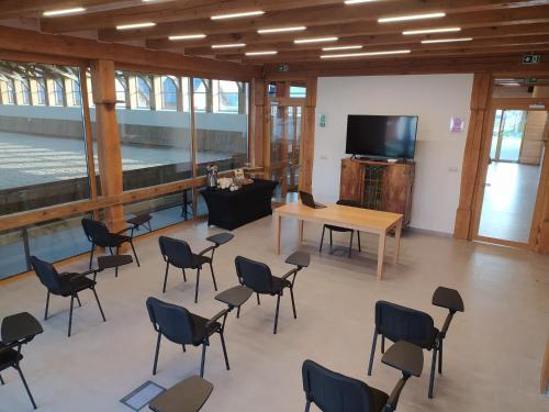 a room with chairs and a table and a television at Apartamenty Stajnia Ojcowizna in Pokrzywnica