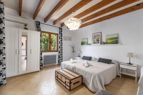 une chambre blanche avec un lit et une table dans l'établissement S'alzinaret, lujosa Villa con piscina, à Bunyola