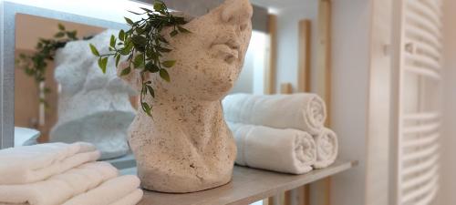 a vase with a plant on a table with towels at Castle Apartman **** in Sátoraljaújhely