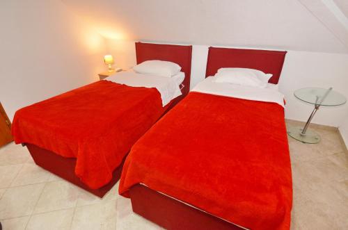 two beds with red covers in a room at Old town central in Kotor