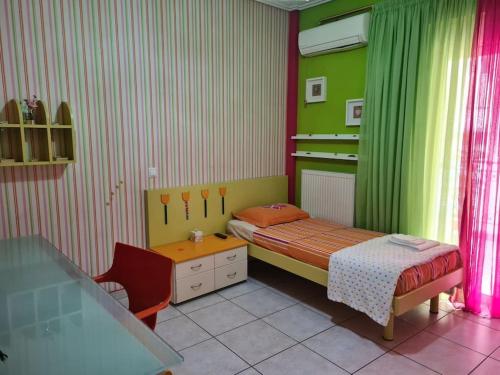 Habitación pequeña con cama y escritorio. en Άνετο, μεγάλο σπίτι κοντά στο μετρό en Pireo
