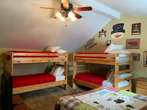 a room with three bunk beds and a ceiling fan at Claim Jumper 9 Townhouse With High Speed Wifi in Red River