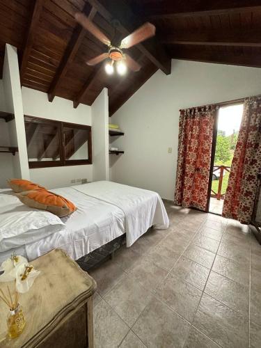 ein Schlafzimmer mit einem Bett und einem Deckenventilator in der Unterkunft Encantos del Valle - Santa Rosa de Calamuchita in Santa Rosa de Calamuchita