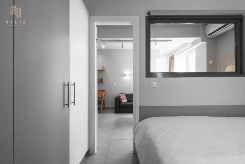 1 dormitorio con cama y espejo en la pared en Big Apple STS, Nilie Hospitality MGMT, en Tesalónica