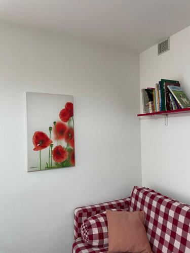 una sala de estar con sofá y una foto de flores rojas en Lake Apartment Ischia Red en Tenna 