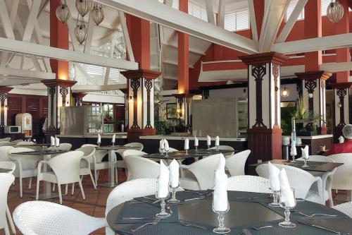 um restaurante com mesas e cadeiras brancas numa sala em Studio "Prestige" Sainte Luce em Sainte-Luce