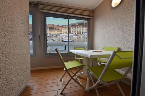 une salle à manger avec une table et des chaises et une fenêtre dans l'établissement deux pièces d'exception, à Port-Vendres