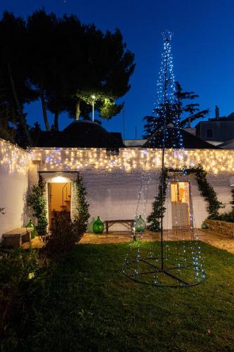 a christmas tree in the yard of a house with lights at Trulli in corte in Alberobello