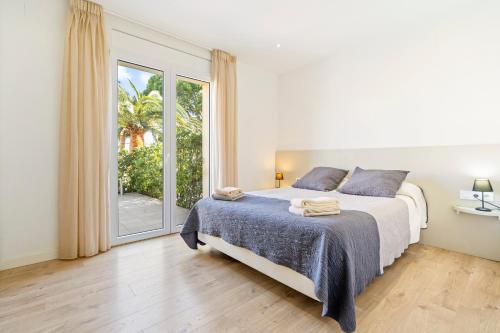 a bedroom with a bed and a large window at La Vida Sin Limites EMP in Empuriabrava