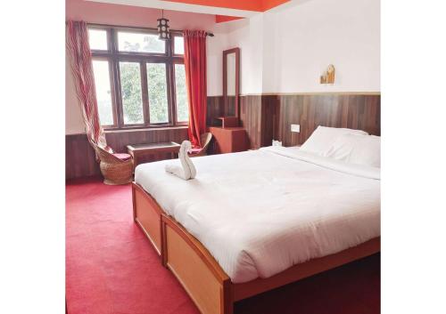 a bedroom with a large bed and a red carpet at Sikkim Heights in Pelling
