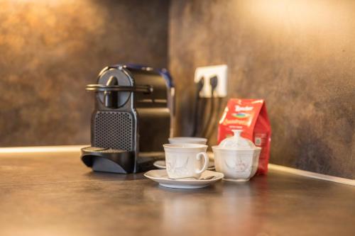 a coffee maker and two cups on a table at Manuel's App Watschinger -Edelweiss in Sesto