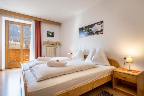 ein großes weißes Bett in einem Zimmer mit Fenster in der Unterkunft Manuel's Edelweiss in Sexten