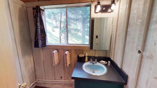a bathroom with a sink and a window at Elk Run A-frame House With Hot Tub And High Speed Wifi in Red River