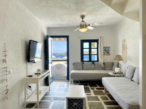 a living room with a couch and a tv at Ocean Vibes Villa by Angels Group Mykonos in Mýkonos City