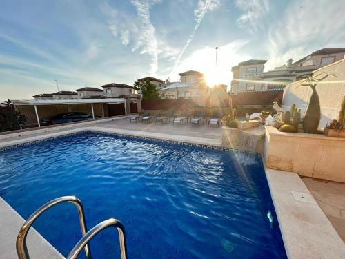 una gran piscina en un patio trasero con puesta de sol en Fantástica Villa Familiar en La Marina, en San Fulgencio