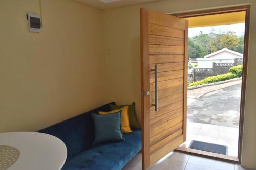 Habitación con sofá azul y puerta de madera. en Tranqulity In Sarnia, en Pinetown