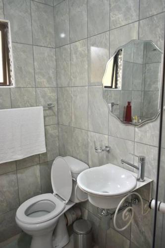 a bathroom with a toilet and a sink at Tranqulity In Sarnia in Pinetown