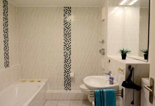 a bathroom with a tub and a toilet and a sink at Ferienwohnungen Steinhof-Littmann in Kippenheim