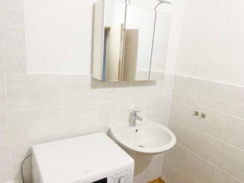 a bathroom with a sink and a toilet and a mirror at Spacious 4 room apartment in Hanau in Hanau am Main