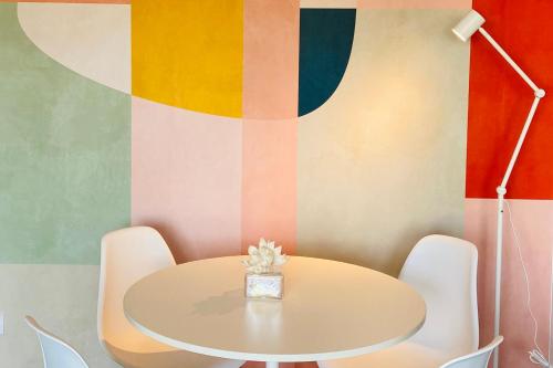 una mesa y sillas en una habitación con una pared colorida en Cosy 39m with terrace in Aubervilliers, en Aubervilliers