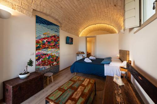 - une chambre avec un lit et une peinture murale dans l'établissement Trulli in corte, à Alberobello