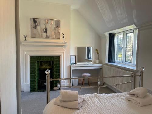 a bedroom with a bed and a fireplace at Thornton House Private Country House Thornton Hough Entire House sleeps 6 in Wirral