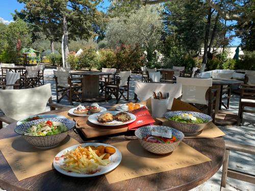 a wooden table with bowls of food on it at Nisi Glamping in Paralia Rachon