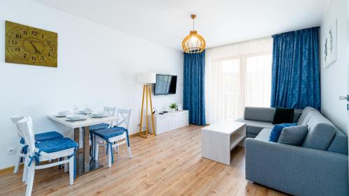 a living room with a blue couch and a table at Apartamenty Sun & Snow Bawaria II in Szklarska Poręba