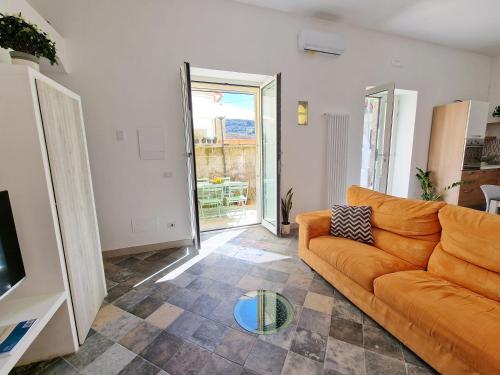 a living room with an orange couch and a television at Casa Gelinda tra Sorrento e Positano in Termini