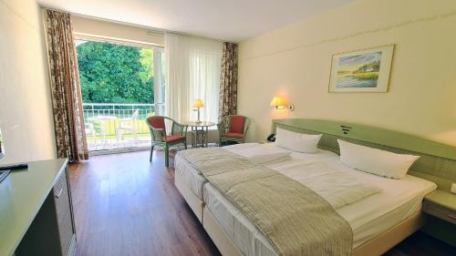 a bedroom with a large bed and a table with chairs at Seehotel Schloss Klink in Klink