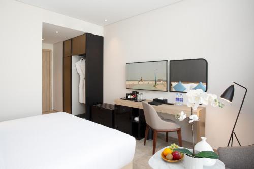 a hotel room with a bed and a desk at Beach Walk Hotel Jumeirah in Dubai