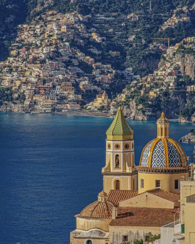 a building with a tower next to the water at Casa Gelinda tra Sorrento e Positano in Termini