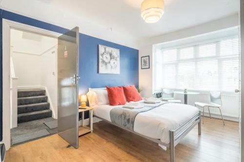 een slaapkamer met een bed en een blauwe muur bij Stylish Studio 4 with Kitchenette by CB Stays no minimum stays in Cambridge