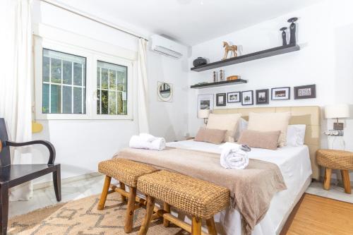 - une chambre blanche avec un lit et deux chaises dans l'établissement LXR Benalmadena 4 Hab. Paradise Villa, à Benalmádena